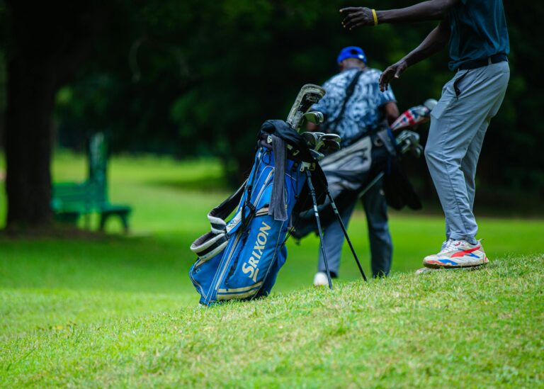 Golfers walking with clubs on a lush green golf course, perfect day for a round.